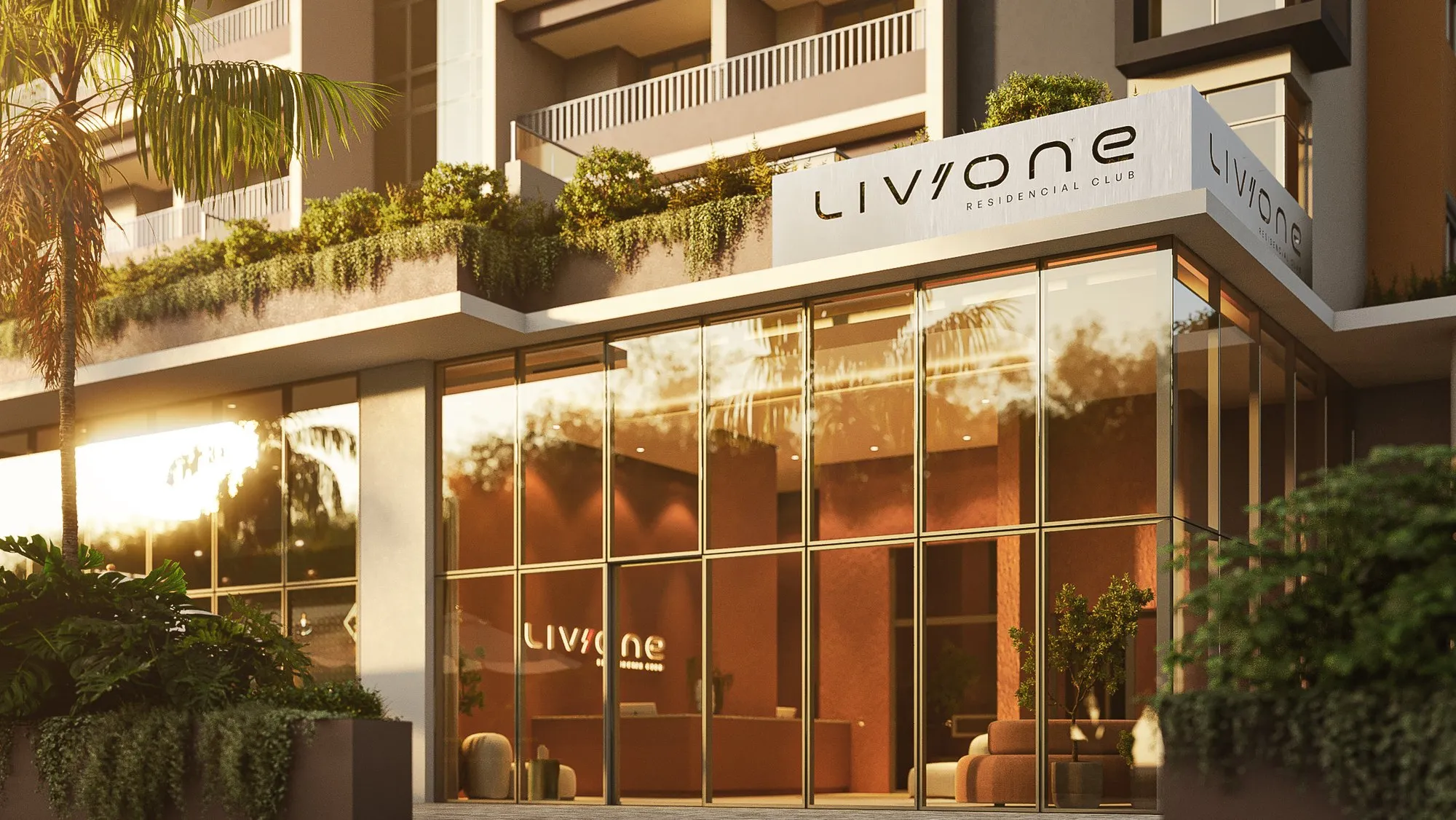 Entrada do Liv One no térreo, com fachada de vidro e jardins nas varandas