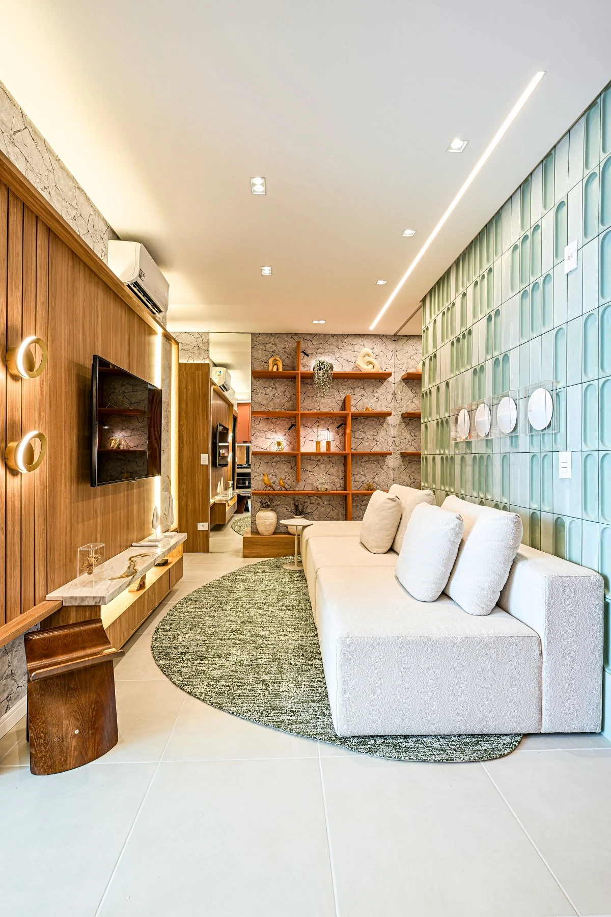 Sala do apartamento decorado do UP Life, com sofá branco, estante laranja e parede de vidro verde